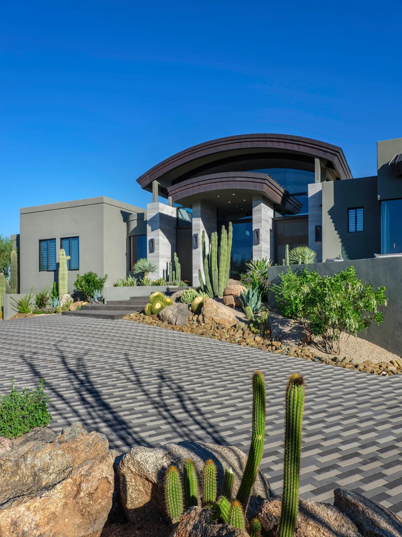 A large house with cactus and plants in front of it.