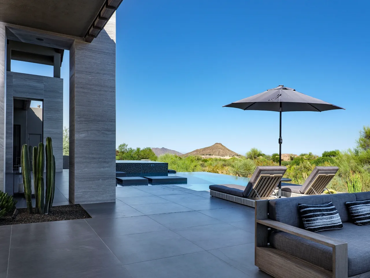 A patio with an umbrella and some chairs