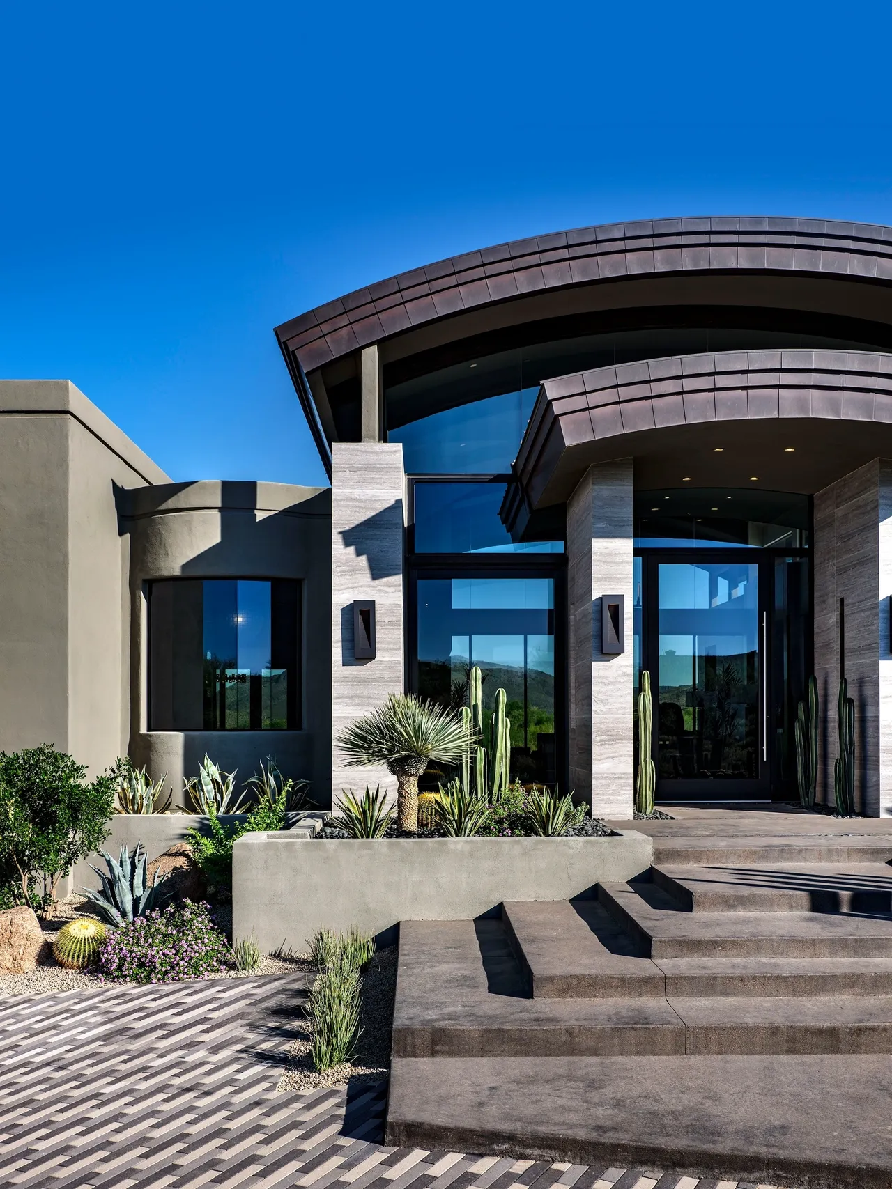 A large modern style home with cactus and succulents.