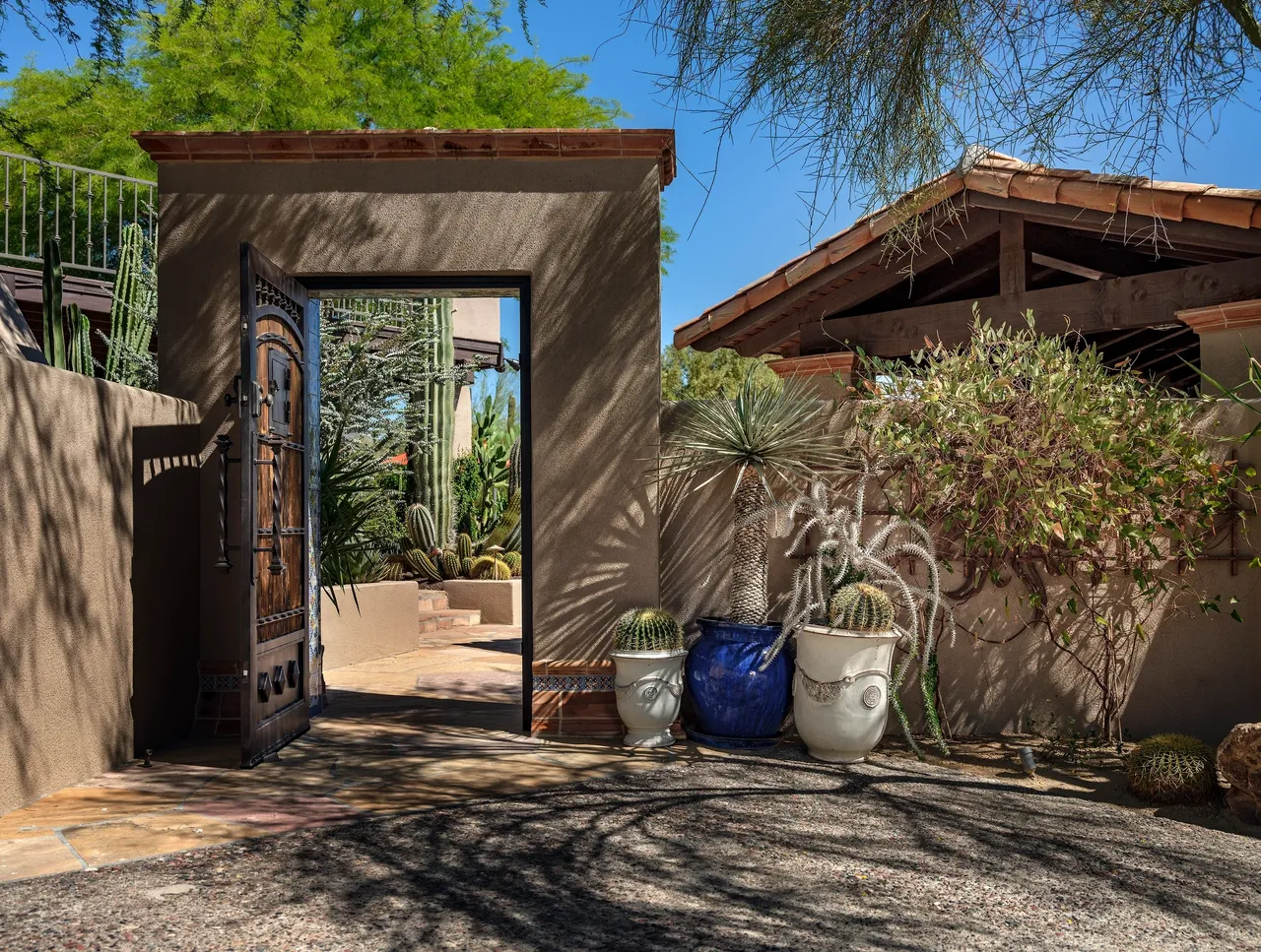 A door way leading to a house with plants in front of it.