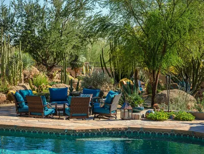 A pool with chairs and tables next to the water.