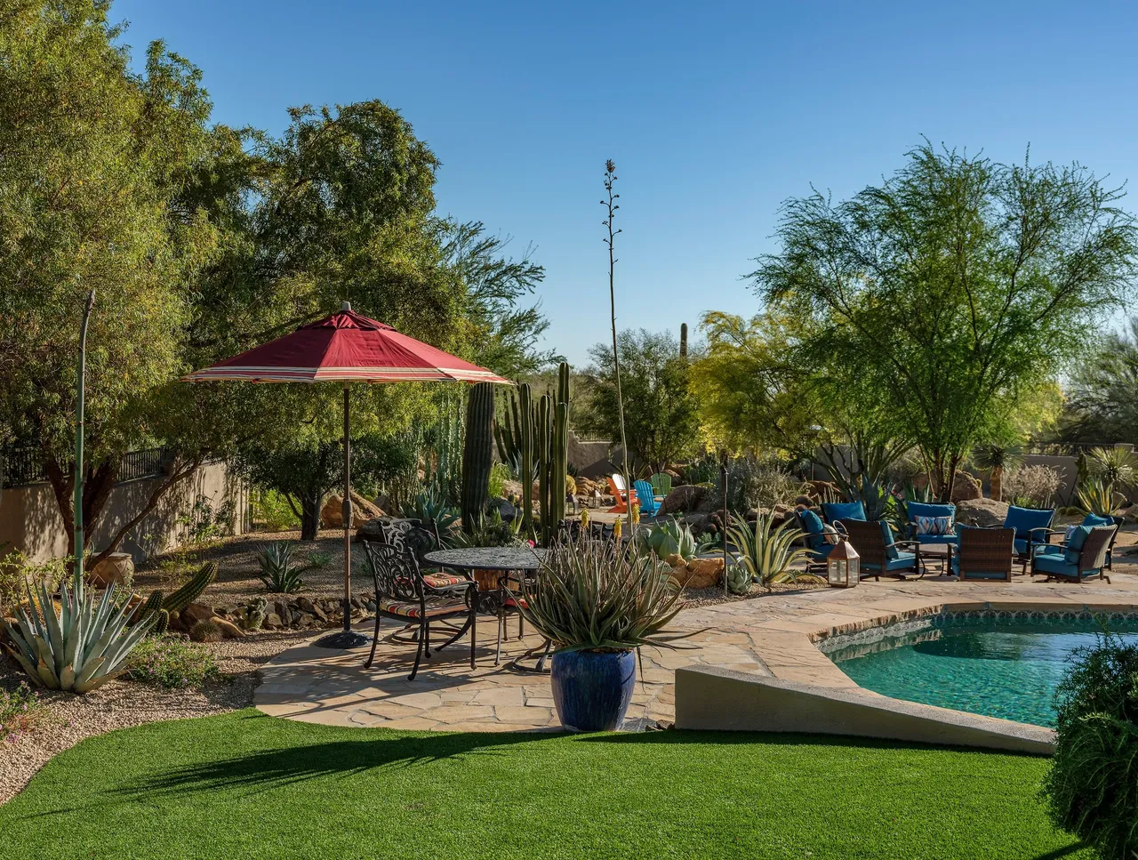 A backyard with an umbrella and pool