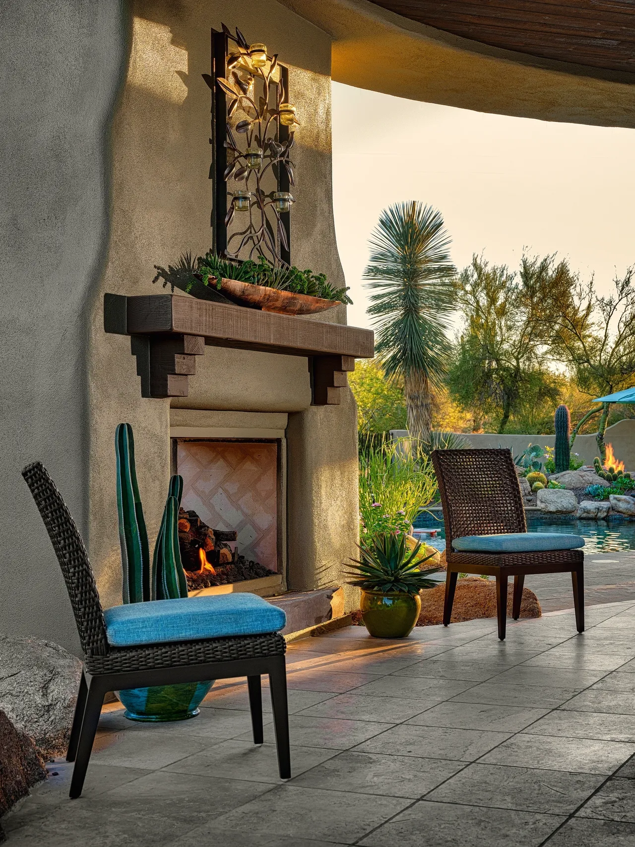 A patio with two chairs and a fireplace.