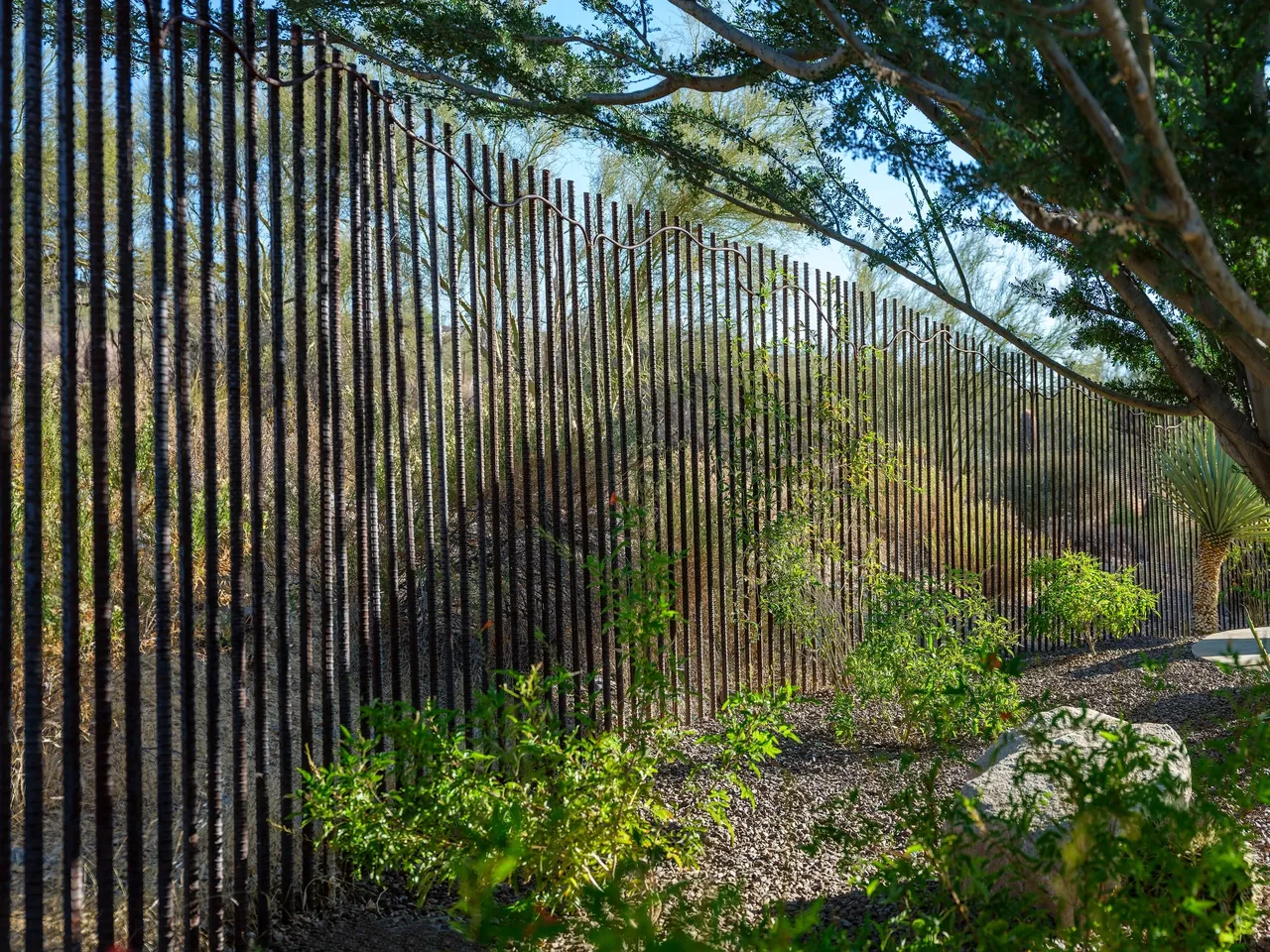 A fence that is made of metal rods.