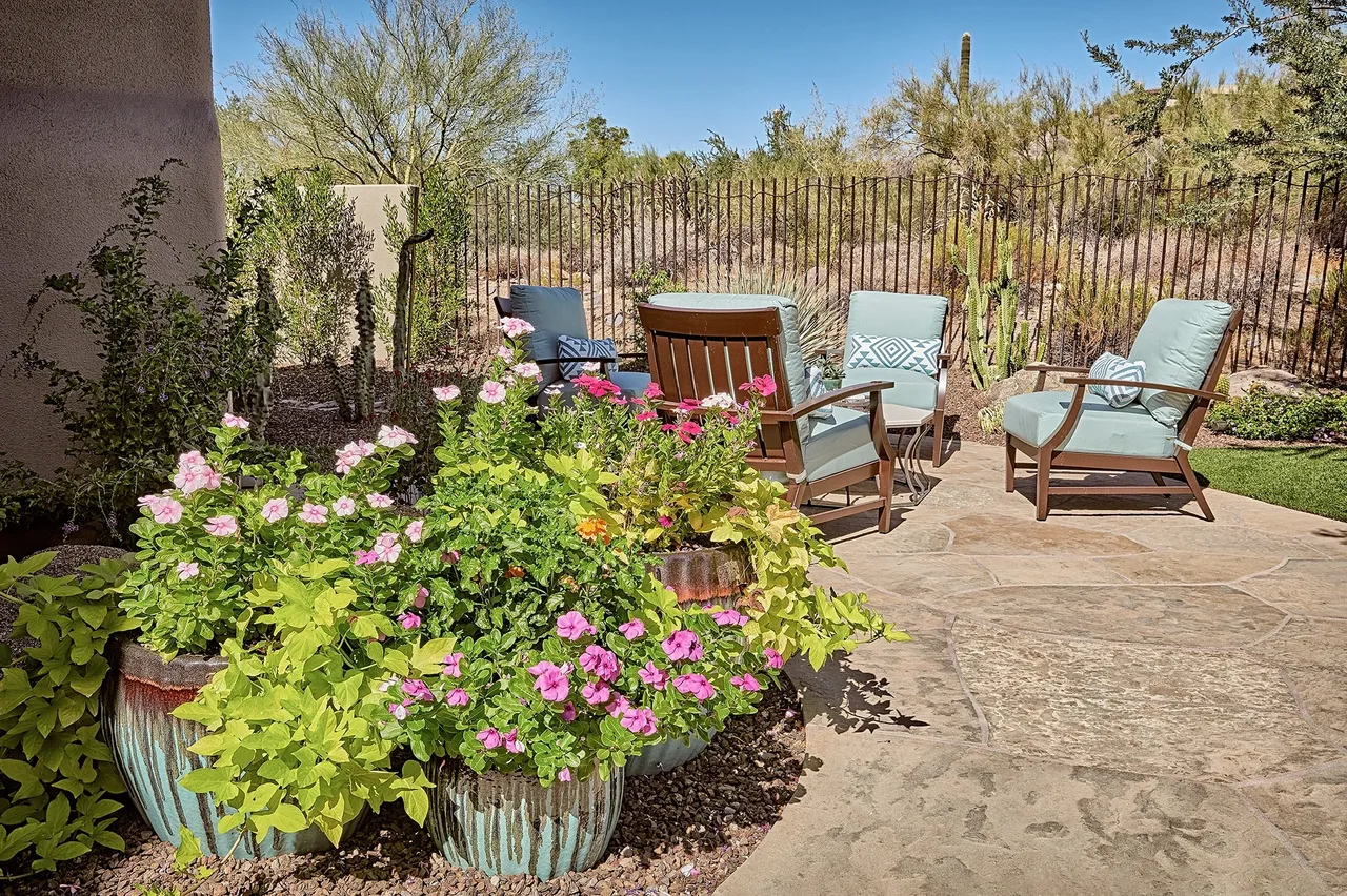 A patio with chairs and flowers in it