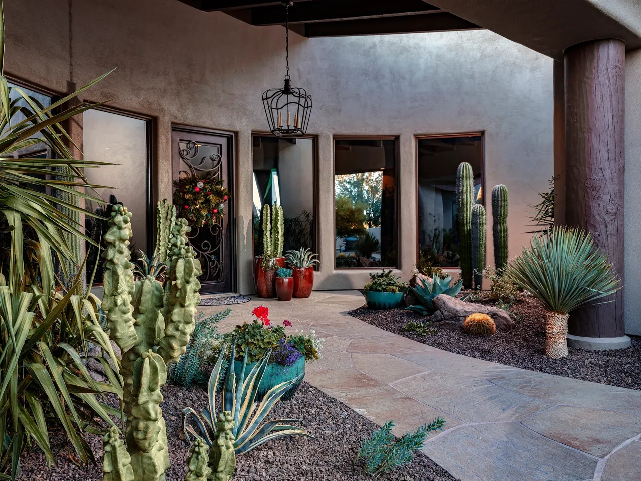 A patio with cacti and flowers in the middle of it.