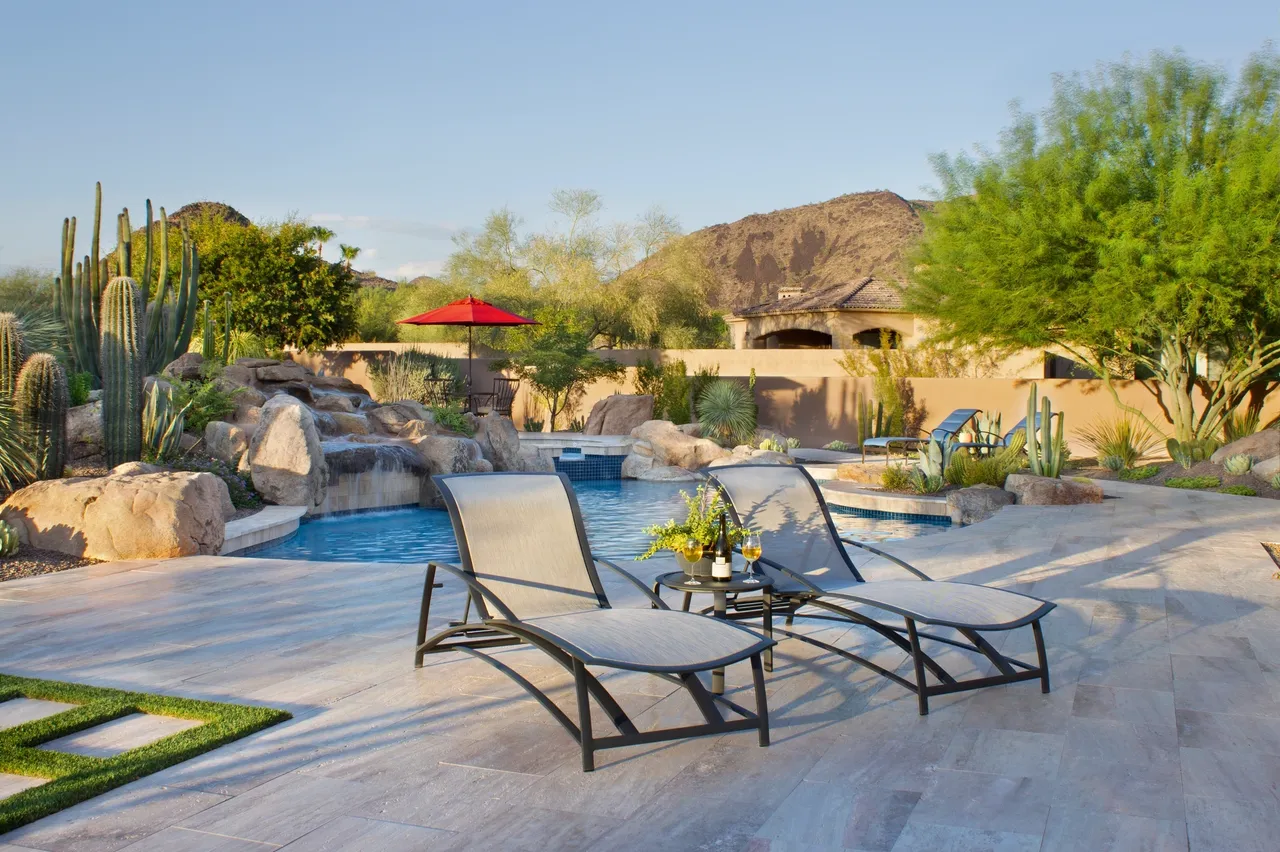 A pool with two lounge chairs and a table