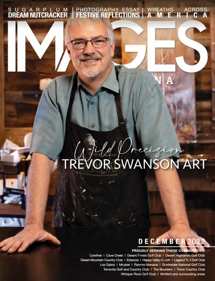 A man in an apron standing next to a table.