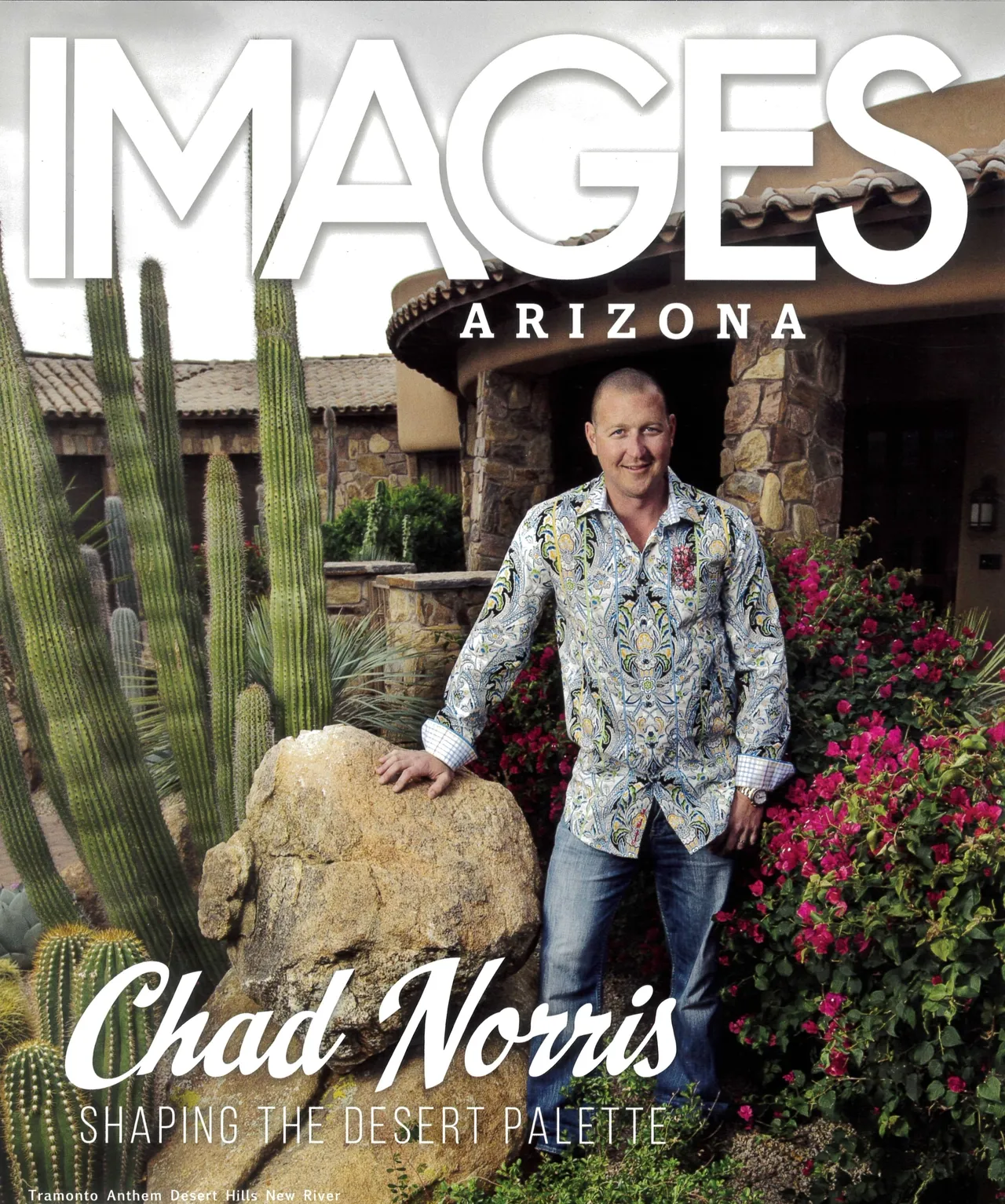 A man standing in front of a cactus and rock.