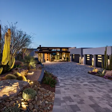 A driveway with a lot of plants and rocks