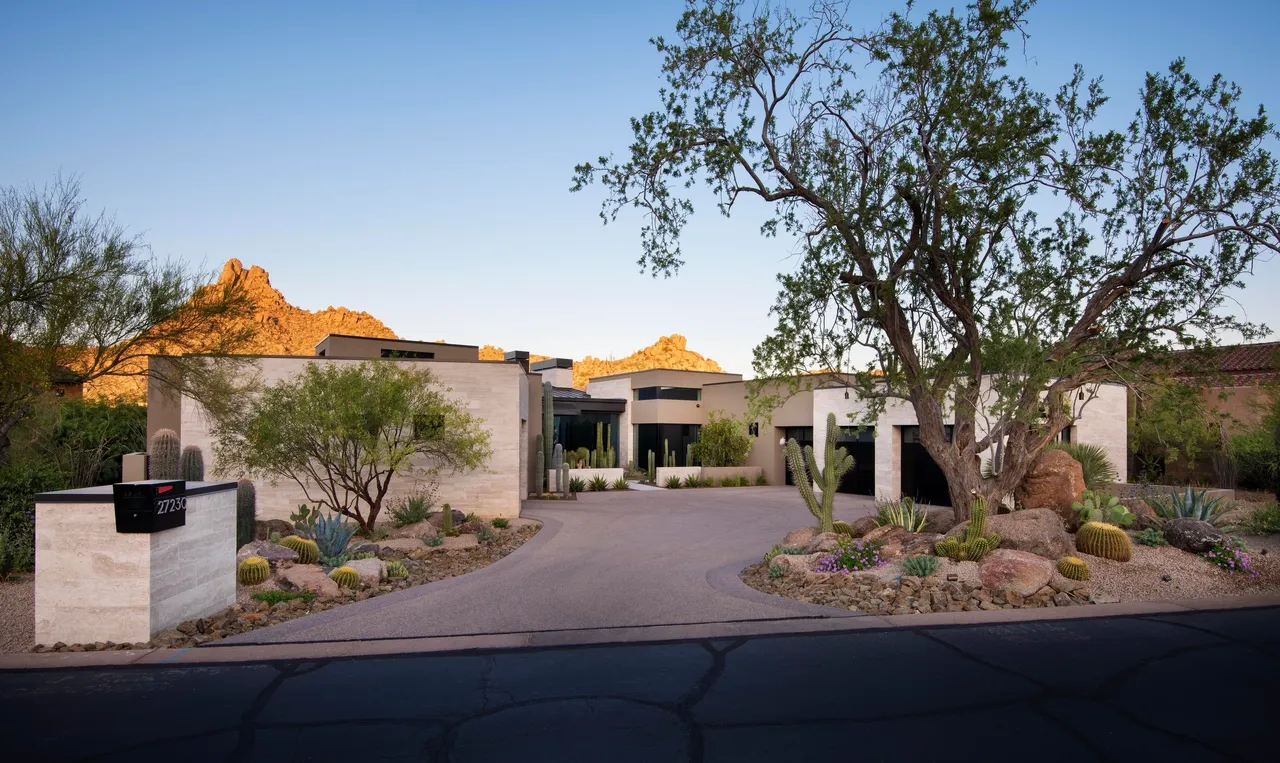 A large driveway with trees and bushes in front of it.