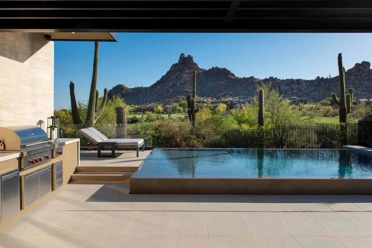 A pool with a view of the mountains and desert.