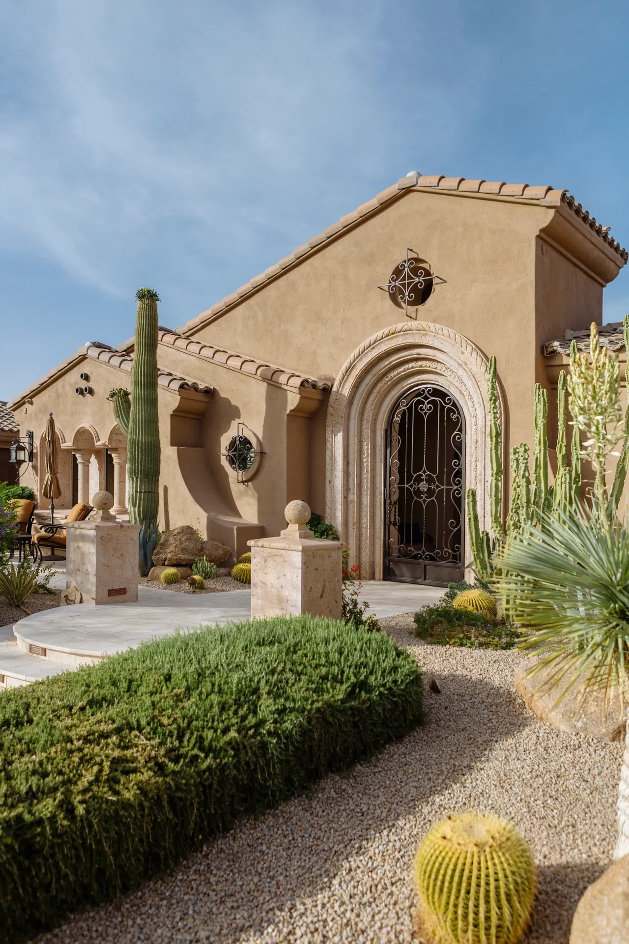 A building with a large cactus in the front yard.