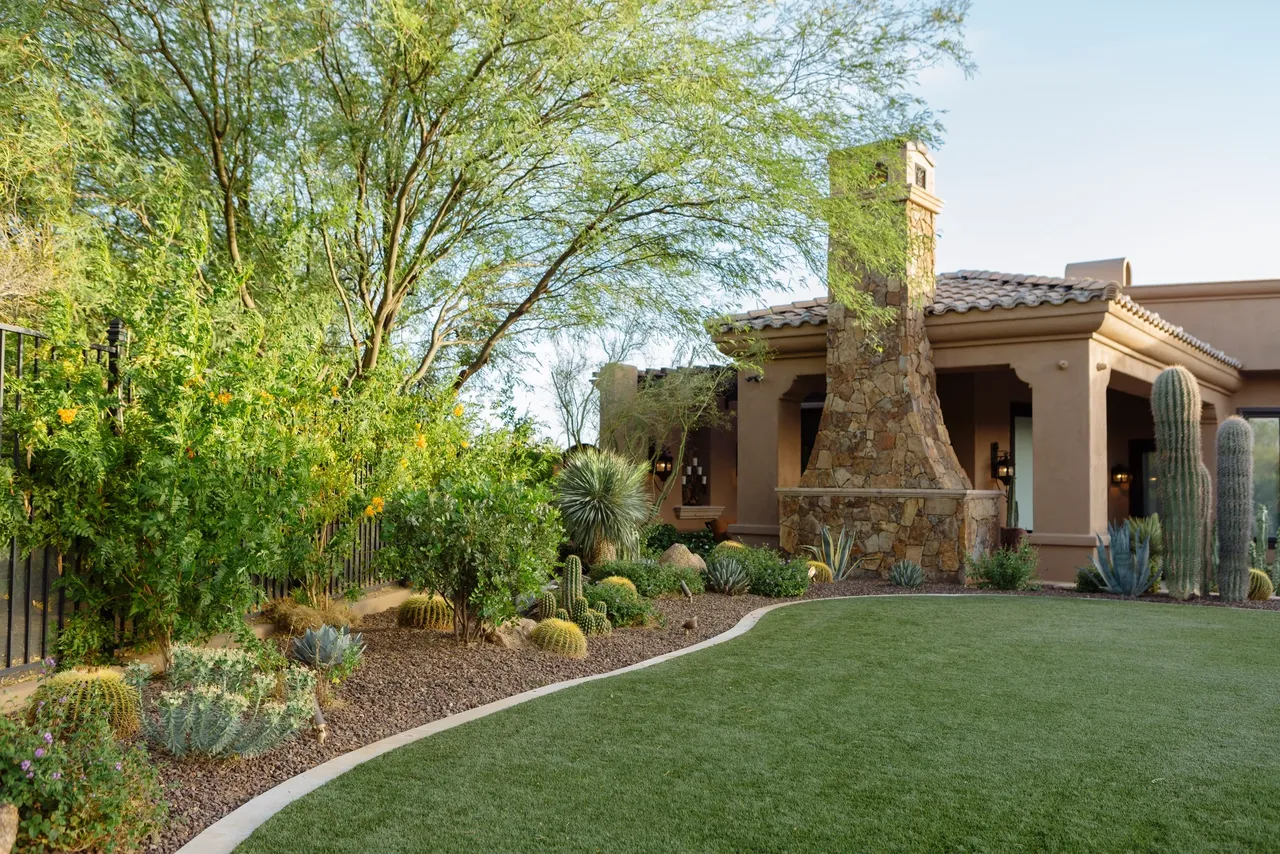 A large yard with a fireplace and lots of trees.