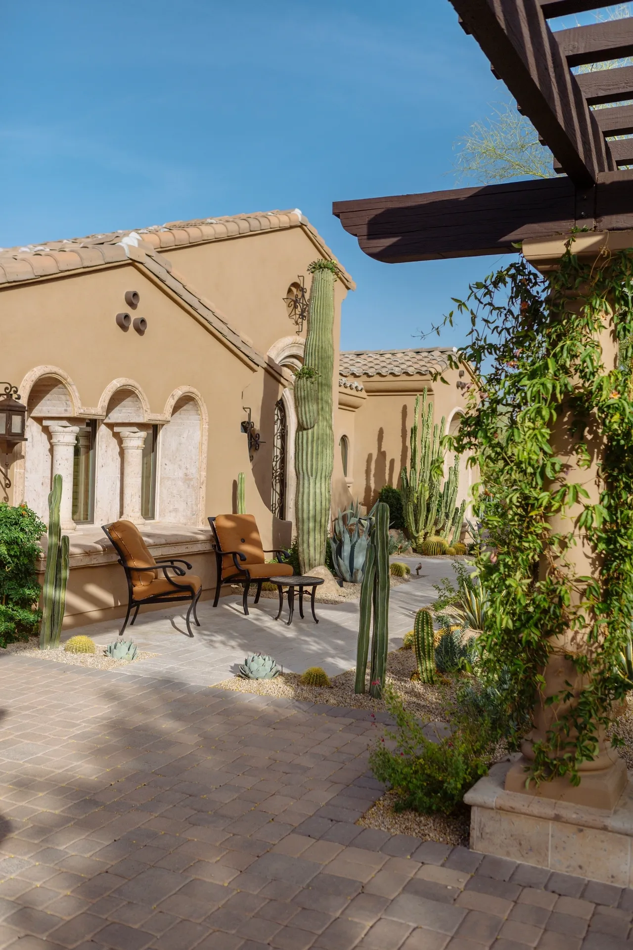 A patio with chairs and tables in the middle of it.