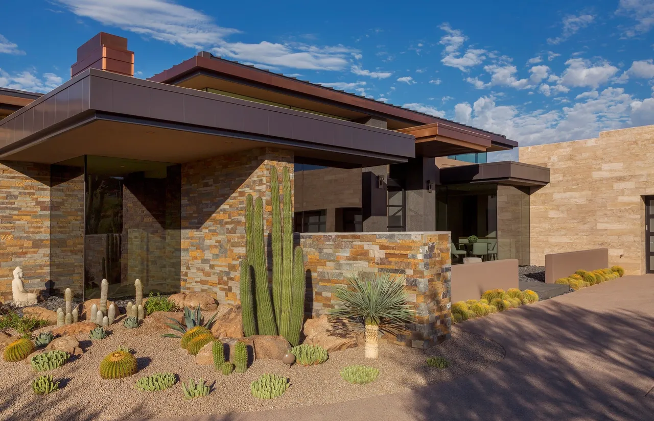 A large house with a cactus in the front yard.