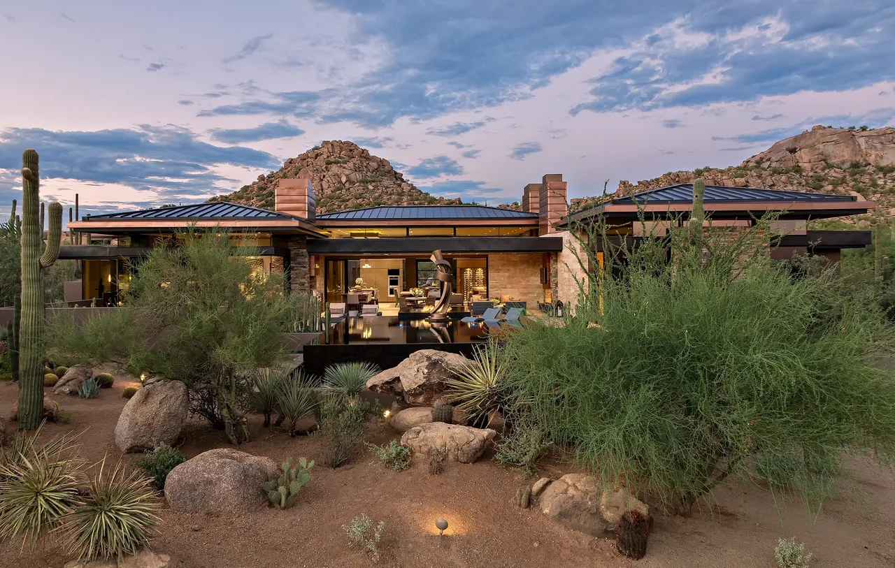 A desert house with a large rock garden.