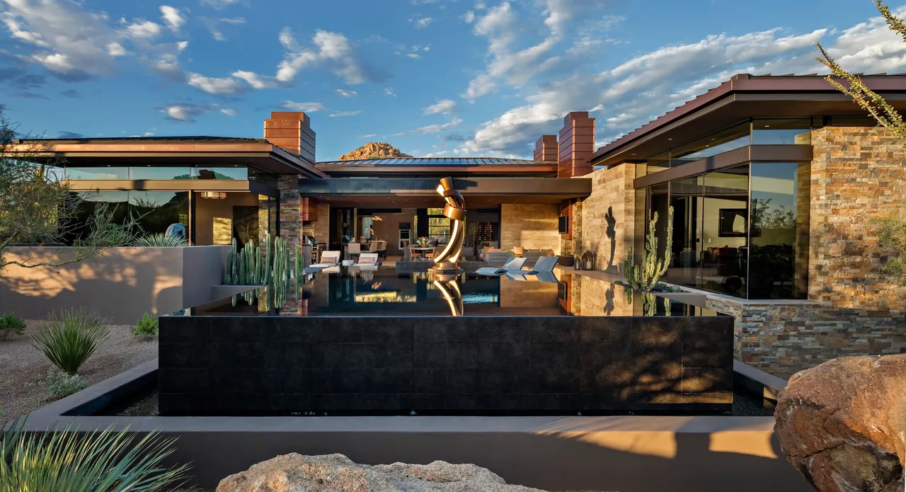 A view of a pool and patio area with a mountain in the background.