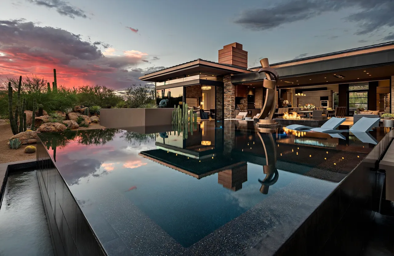 A pool with a view of the sky and a house.