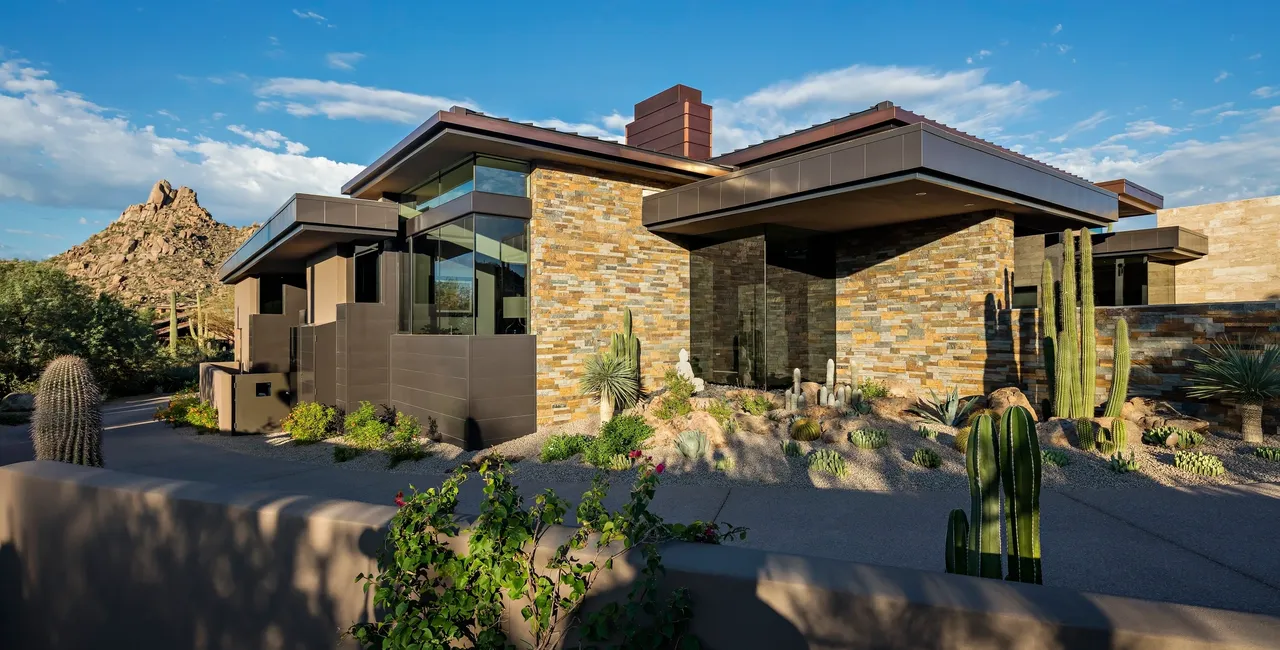 A house with a large window and a stone wall.