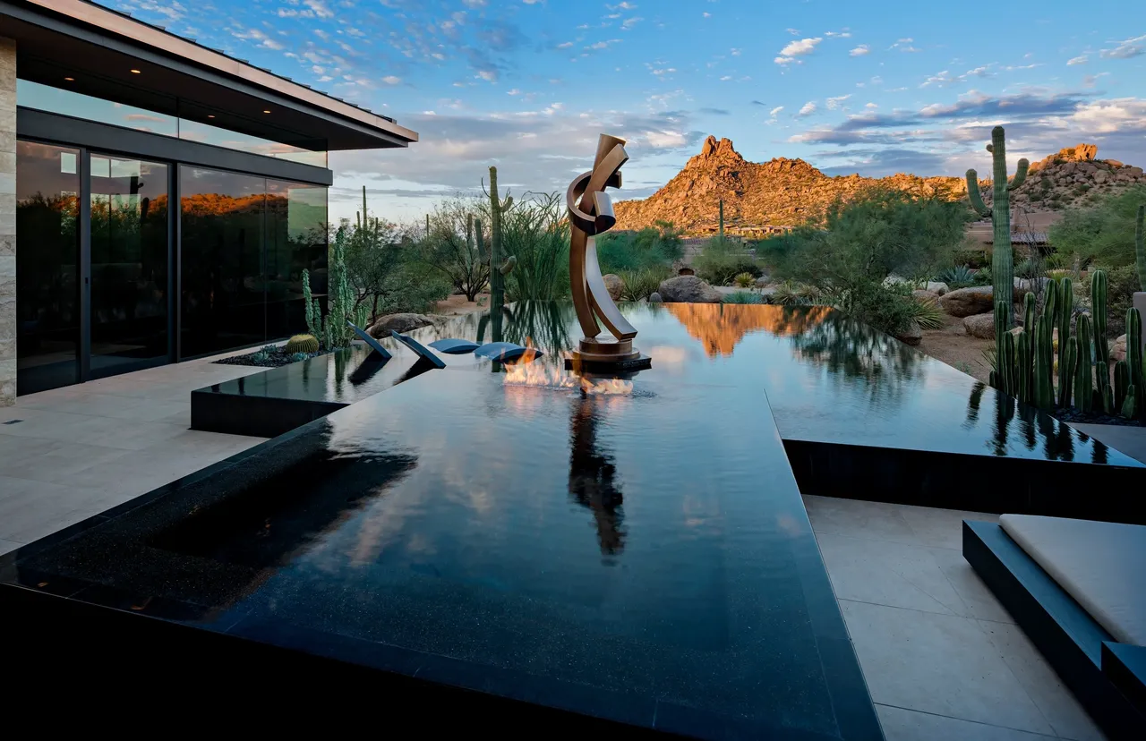 A statue of a person in front of a pool.