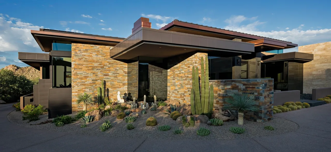 A house with a lot of cacti in front