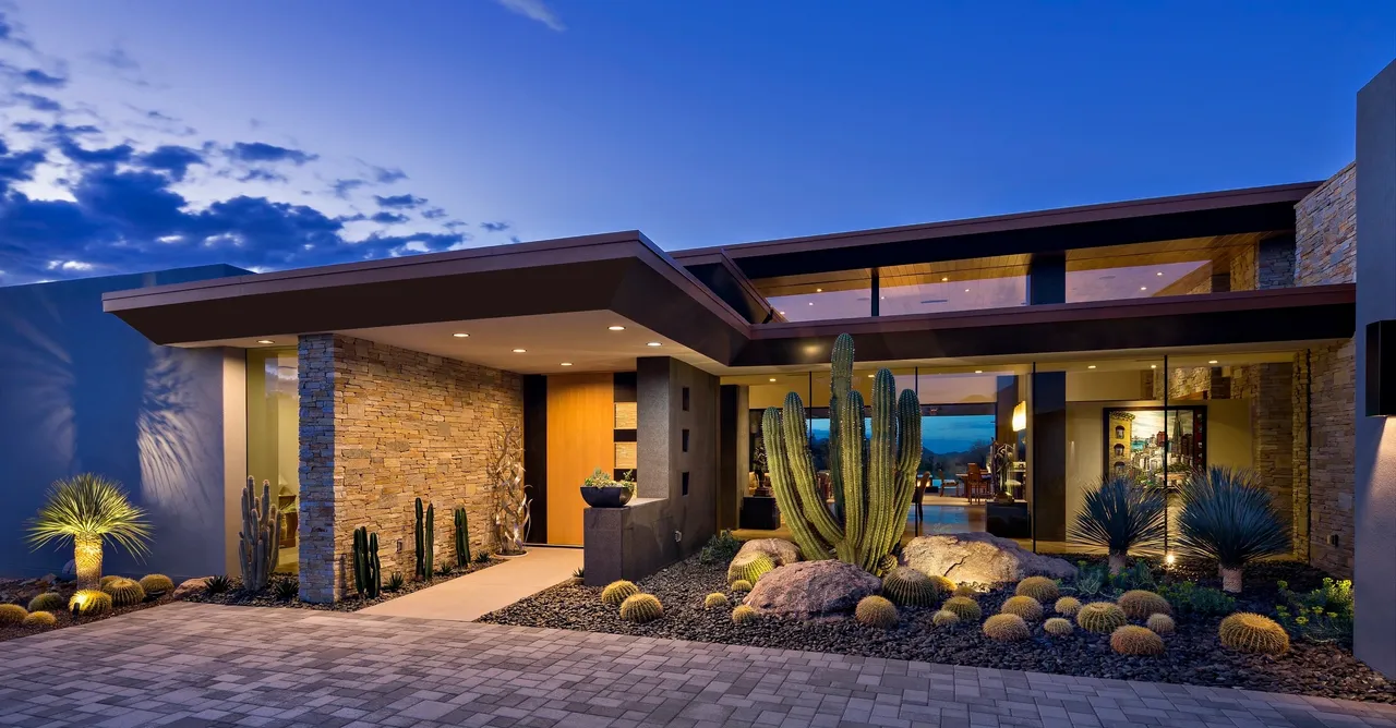 A large cactus in front of a house.