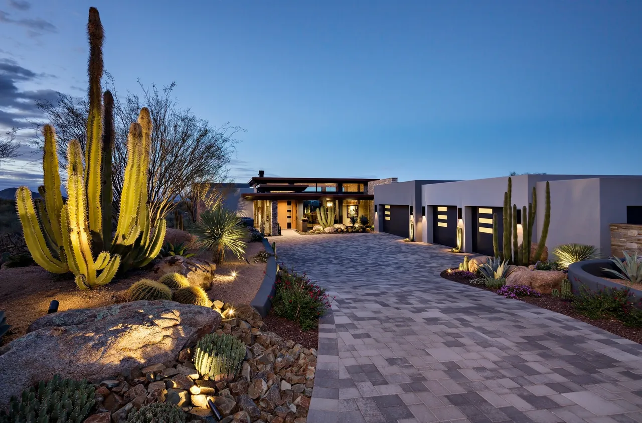 A driveway with a lot of landscaping and lights