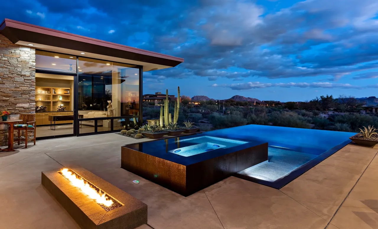 A pool with an outdoor fire pit and hot tub.