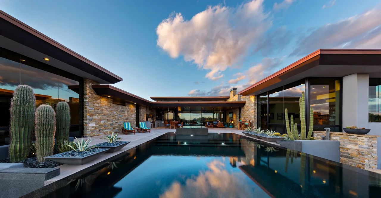 A pool with a large stone wall and a sky background