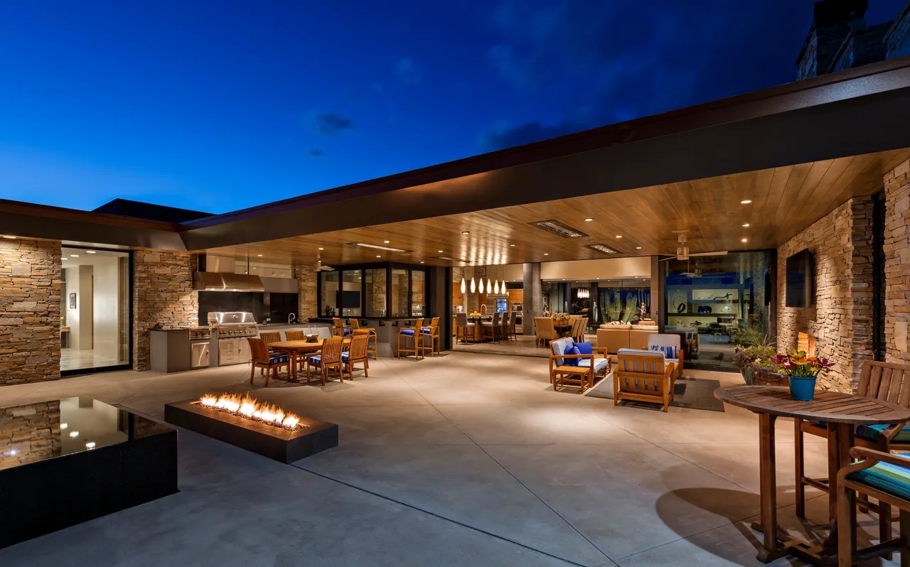 A large patio with fire pit and outdoor furniture.