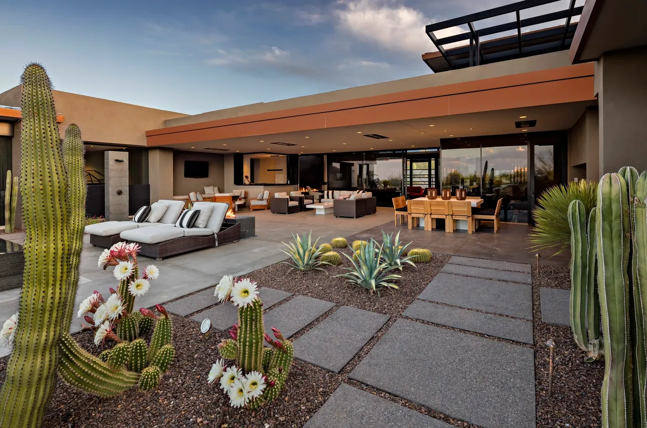 A patio with flowers and furniture in it.