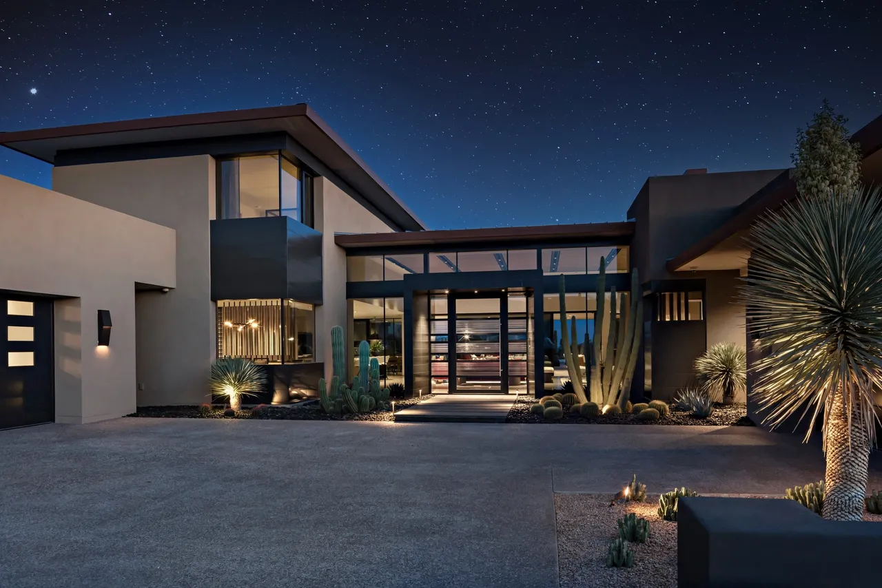 A large modern house with a lot of lights on the outside.