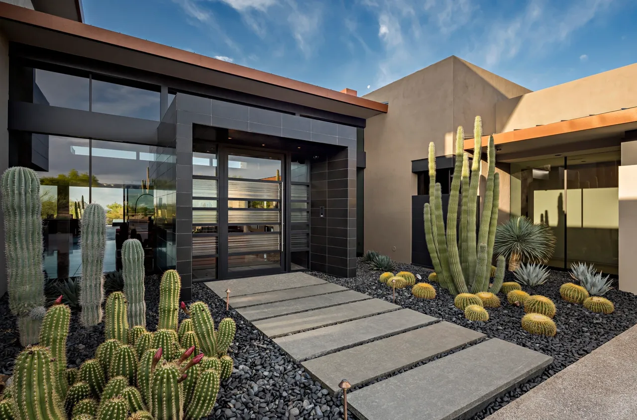 A house with a lot of cacti in the front yard