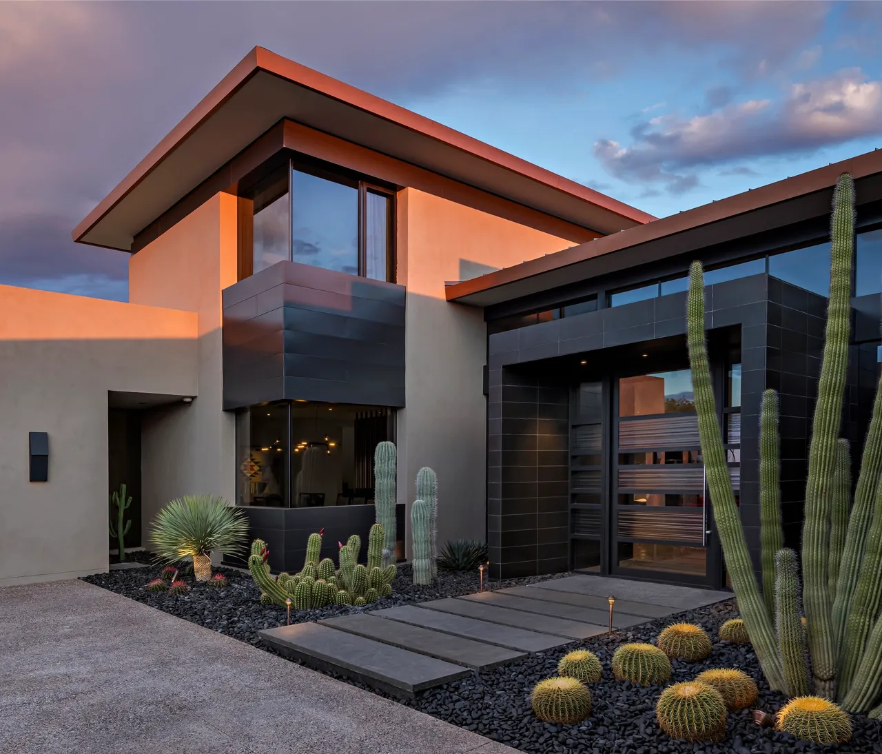 A modern house with cactus and a sunset