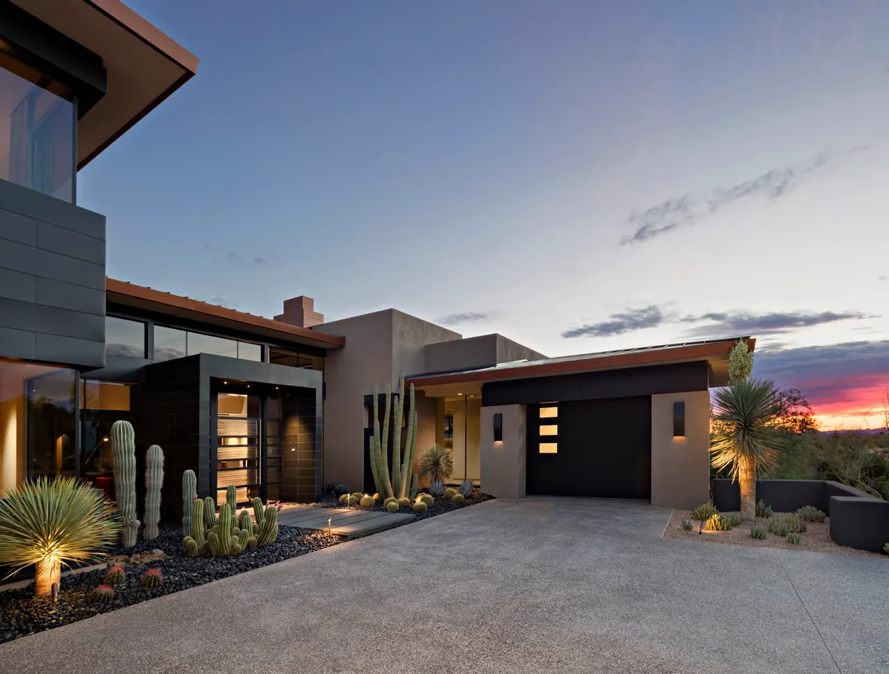 A modern home with cactus and desert plants.