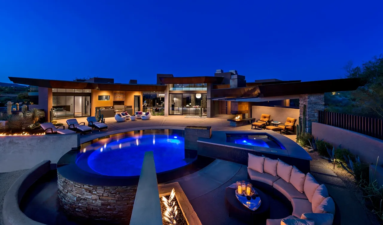 A pool with a fire pit and a large patio.