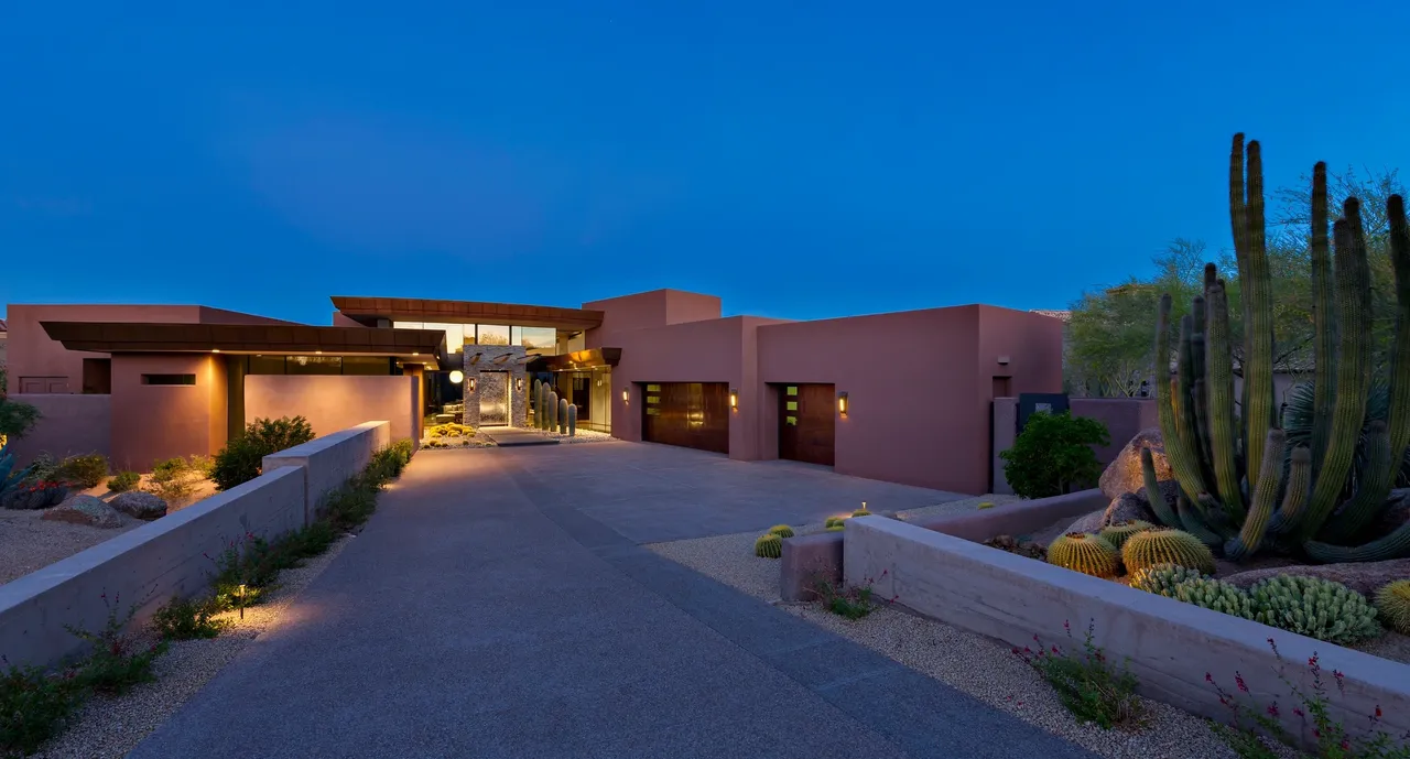 A large driveway with three cars parked in front of it.