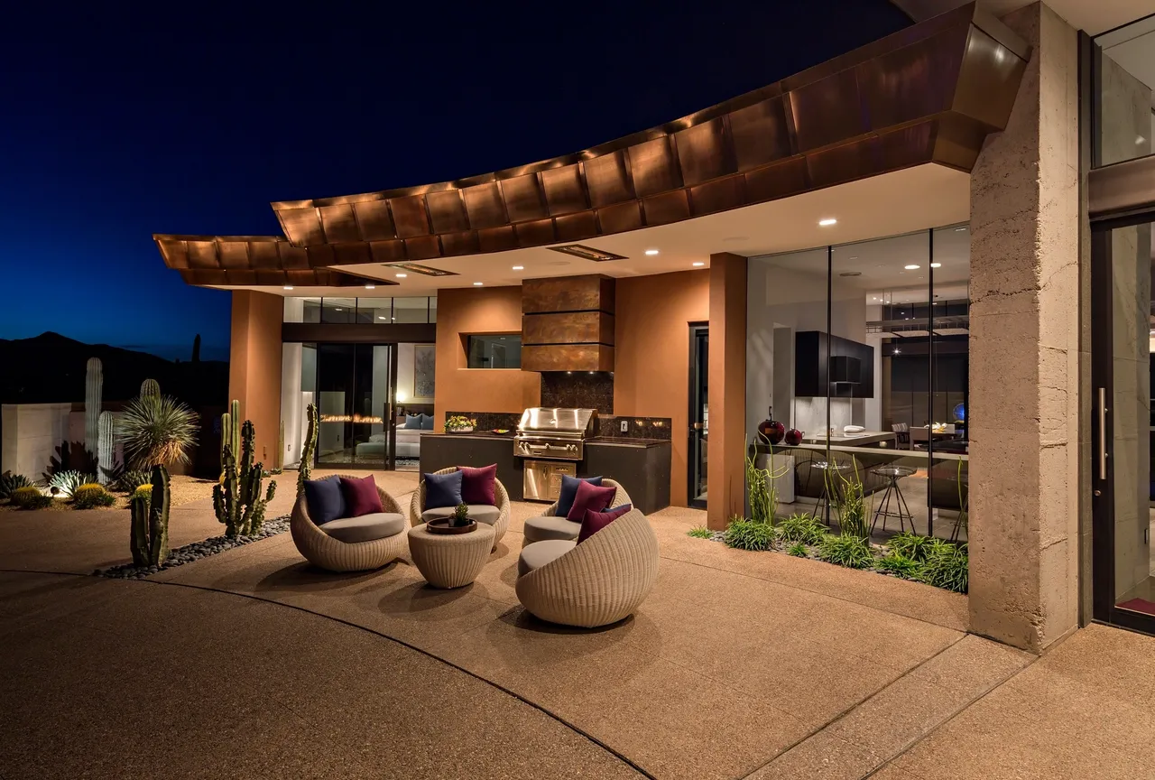 A patio with chairs and an outdoor grill.