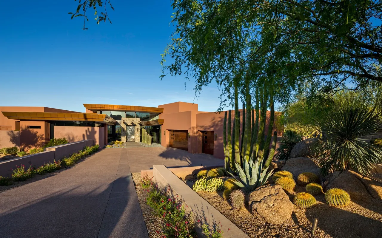 A large driveway with a house and cactus