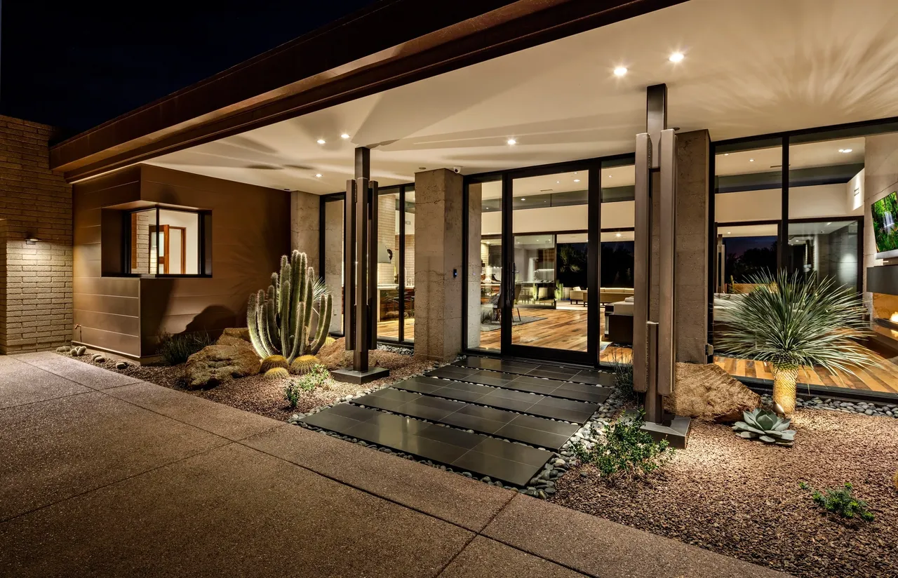 A large entrance way with glass doors and plants.