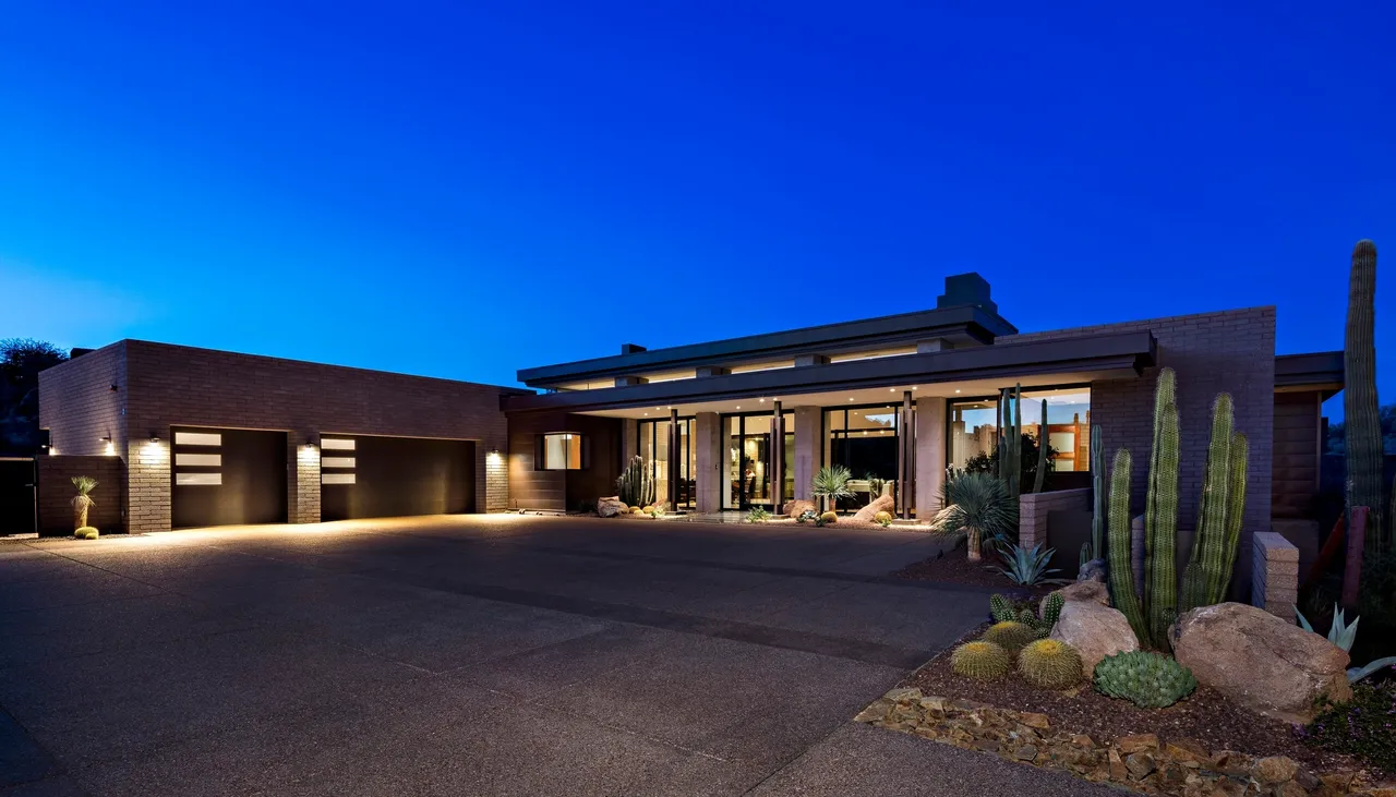 A large driveway with a garage door open.