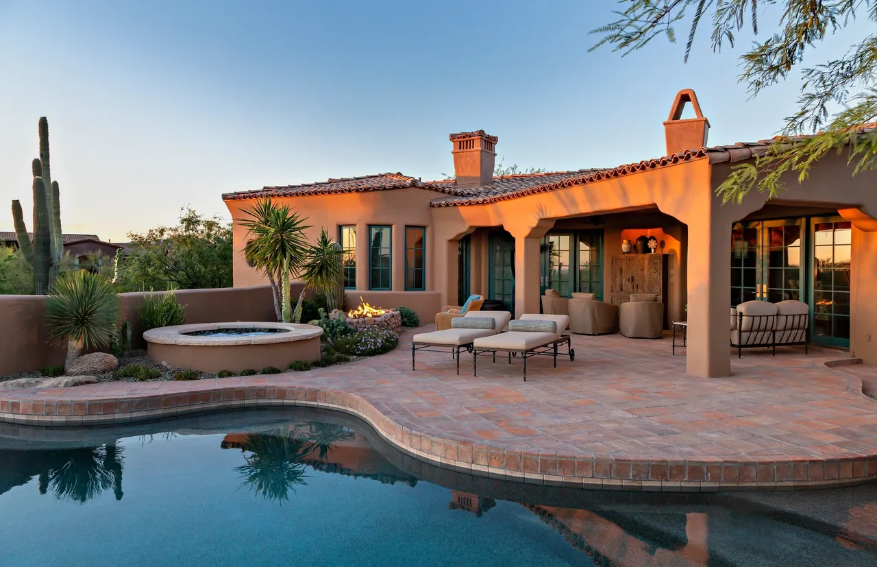 A pool and patio area with a jacuzzi.