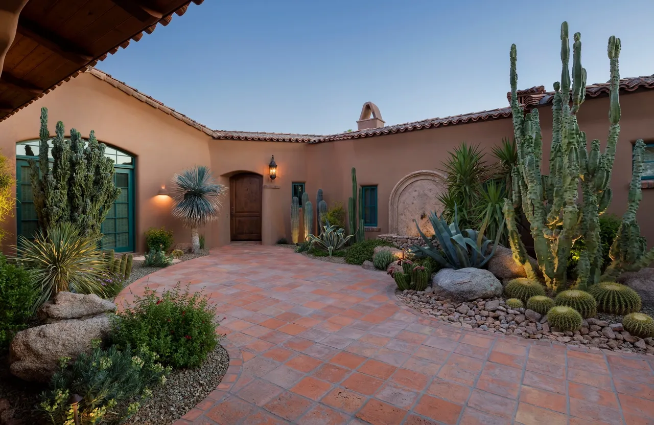 A courtyard with cactus and plants in the middle of it.