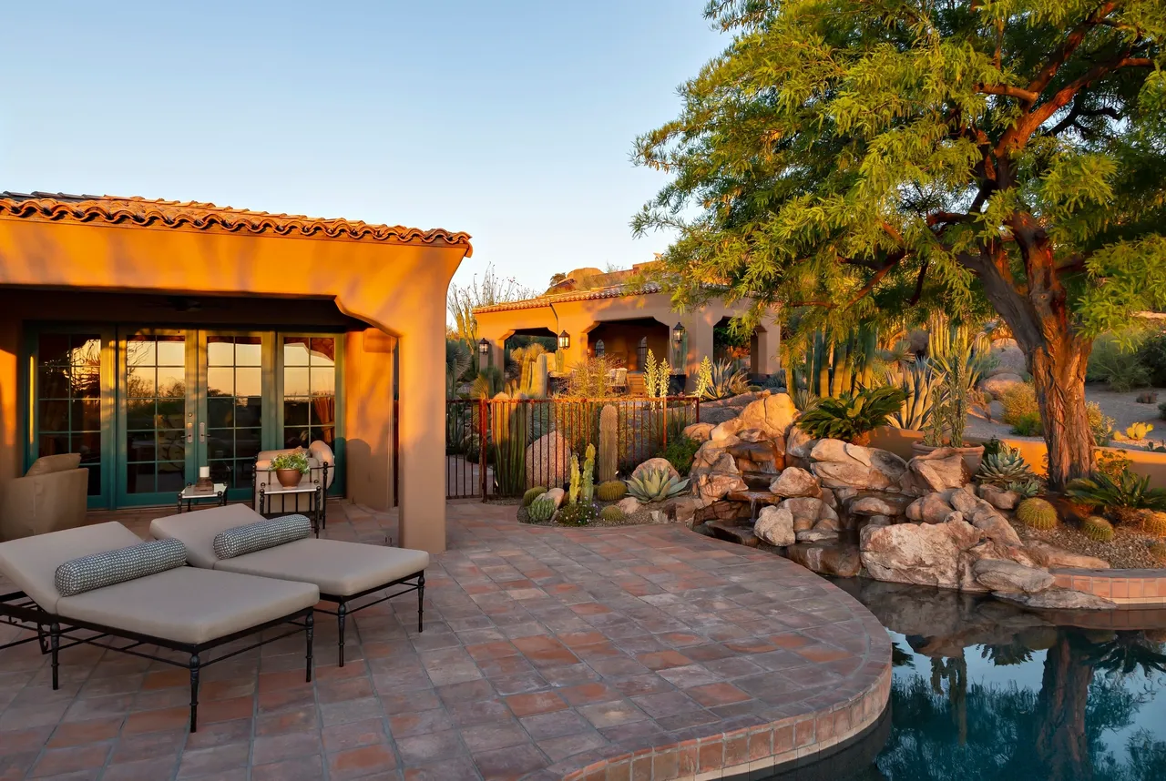 A patio with a pool and a tree